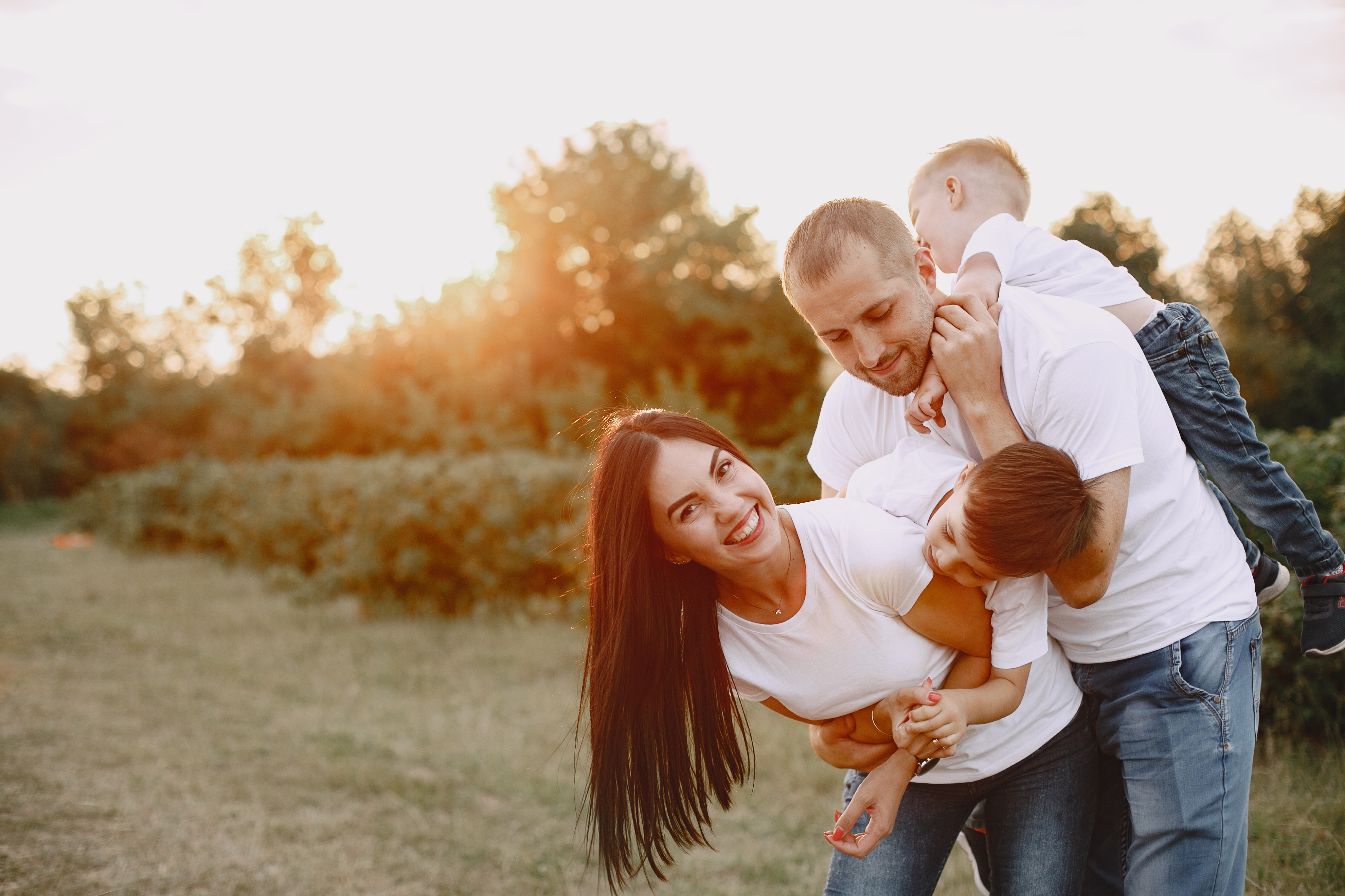 Family with cute little child. Father in a white t- shirt. Sunset background.